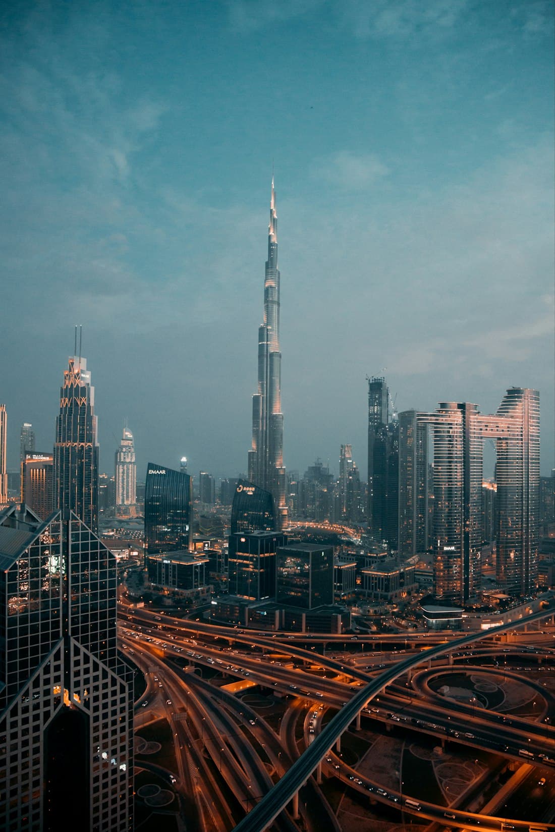 The Burj Khalifa and surrounding towers at dusk under a deep teal sky.